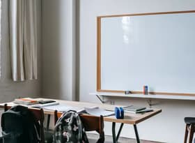 School bench with stationery in classroom
